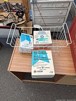 Top view of assorted new construction and flooring materials including mortar bag, adhesive, and wire rack shelf