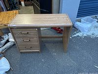 Photo showing the full desk front view with three drawers on the left and leg space on the right.