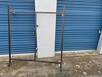 Front view of the double metal bed frame showing the main structure with metal beams and wheels on the bottom.