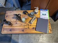 Photo showing miscellaneous knickknacks arranged on a wooden table in an indoor setting.