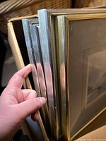 Close-up of several metallic-style picture frames held together, showing silver and gold finishes.
