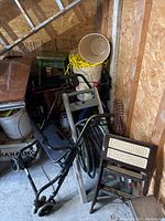 Overall view of walker, buckets, rope, hose, and step stools in storage space