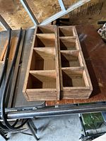 Photo showing two wooden cube organizers side by side on a wooden table surface with black metal legs beneath.
