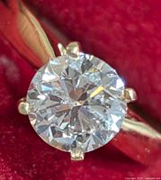 Top view of round brilliant-cut diamond in six-prong setting on gold band