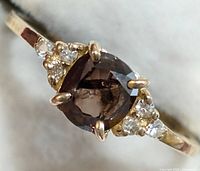 Close-up front view of ring head showing cushion-cut brown diamond flanked by white diamonds