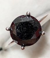 Top view of round black diamond and six-prong white gold setting