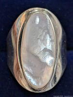Top-down close-up of the silver ring showing the mother of pearl stone and band detail.