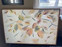 Full view of the oil painting showing autumn leaves on white background with wooden frame.