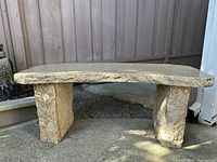 Two-piece cream marble bench, front view showing curved top supported by two slab legs
