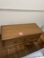 Top angled view of cedar chest showing multiple drawers and lower compartment doors with decorative handles.