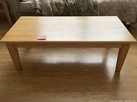 Maple coffee table showing full top view and legs on wood floor