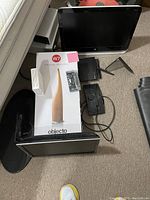 Photo showing HP monitor, wireless router, monitor stand, power adapters, and other electronic items alongside W7 Ultrasonic Humidifier box