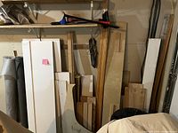 Photo of assorted wood pieces including plywood panels, planks and cut sections, along with landscaping paper roll.