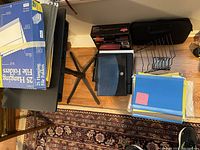 Photo showing various file folders, hanging file folder box, laptop stand base, Bissell sweeper box, and a small black zippered laptop sleeve.