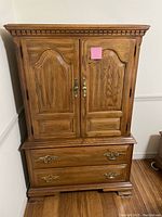 Front view of oak dresser showing upper cabinet with double doors and lower section with two large drawers