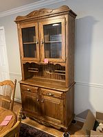 Full view of solid oak two-piece hutch showing front with glass doors, drawers and base cabinet