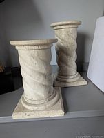 Front view of the pair of travertine pillars showing twisted column design and square bases