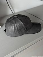 Side view of ceramic baseball cap planter showing curved bill and cap panels