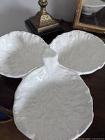 The cabbage leaf-shaped serving tray with fine detailing and glossy white glaze.