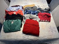 Folded assortment of boys shorts, boys shirts, and ladies tops arranged on a table