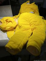 Yellow padded full-body suit laid out flat including longs arms and legs and attached feet.