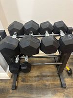 Frontal view of rack loaded with 35 lb, 25 lb, and 15 lb hex dumbbells