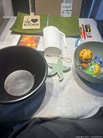 Photo showing wooden bowls, wooden salad plates, white milk container, kids balloons, and small kitchen items on table