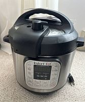 Front view of Instant Pot Duo electric pressure cooker showing lid and handle.