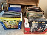 Two cardboard and branded store boxes filled with LP record sleeves