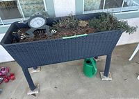 Full view of elevated planter box with soil and small plants, including a frog thermometer (not included in sale) on top.