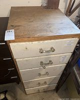 Wooden drawer cabinet with five drawers with worn white drawer fronts and glass or acrylic handles