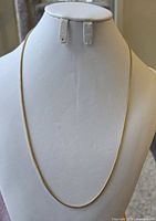 Full view of gold chain draped over display bust