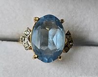 Front view of ring showing oval blue center stone