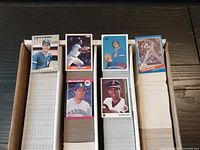 Close-up view of the baseball cards on top of each stack, showing different player cards from various 1989 sets and one from 1991 Donruss.