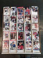 Top view showing front sides of various hockey trading cards arranged in 5 columns inside a box. Each card depicts a hockey player mostly in full uniform and different poses.