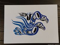 Photo of unsigned First Nations print with black and blue stylized bird design on white background