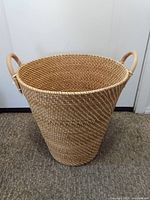 Front view of large wicker basket showing tapered shape and handles