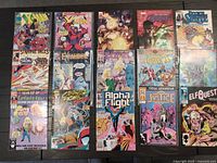 Full view of all 15 Marvel comic books arranged in three columns on a dark wood surface, showing covers and titles clearly for condition and identification.