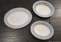 Three pieces of Royal Doulton Valleyfield pattern bone china: one large meat platter and two vegetable bowls shown side by side on a dark surface.