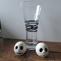 Salt and pepper shakers with vase centered behind on wooden surface, showing overall condition and scale