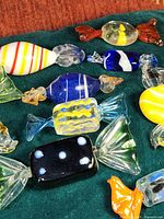 Close-up showing colorful assortment of hand blown Murano art glass candies with distinct candy shapes and twisted wrapper ends.