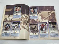 Open album pages showing NHL player cards from the 60s, 70s, and 80s with players like Gordie Howe, Pete Plot, and Lorne 'Gump' Worsley on vintage hockey photos background.