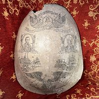 Full view of the large etched shell replica showing detailed American historical etching and damage