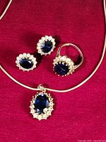 Necklace, ring and pair of earrings arranged on red background