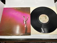Front cover of Queen's 1973 debut album showing a purple to black design with faint handwritten name and some edge wear.