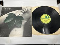 Front cover, vinyl, and original inner sleeve shown flat with record face up on the right.