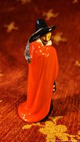 Front and side view of Royal Doulton Guy Fawkes porcelain figurine in orange cloak, black hat, holding a lantern