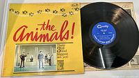 Front cover of The Animals 'Animal Tracks' LP record showing the band photo and yellow background with red text.
