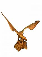 Showcasing the brass eagle figurine from the front angle with wings spread and perched on a rock base.