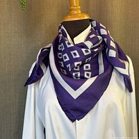 Scarf displayed tied around mannequin neck showing figure and how it looks worn.